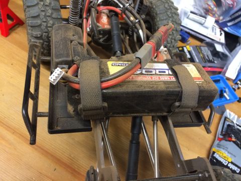 1989 Ford Bronco - The chassis of a remote control car is shown, an Onyx 5000mAh battery pack secured with straps and visible wiring.