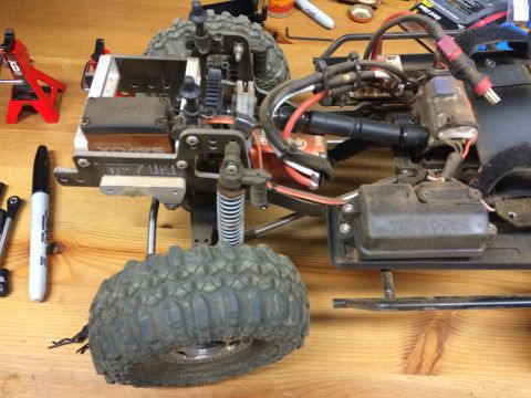 1989 Ford Bronco - Close-up of an RC car's internal components and suspension system on a wooden surface.