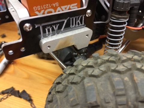 1989 Ford Bronco - A component of a remote-controlled vehicle, a prominent brand logo and part of the suspension system.
