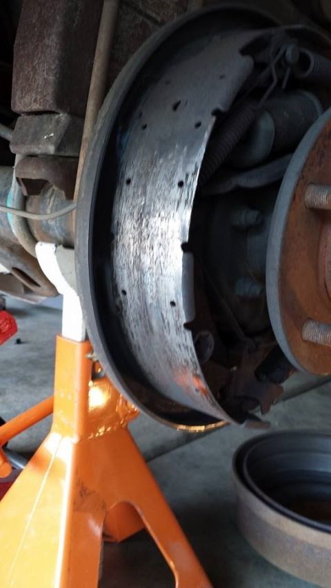 1996 Ford Bronco - This photo shows a close-up view of a vehicle's drum brake assembly, supported by an orange jack stand.