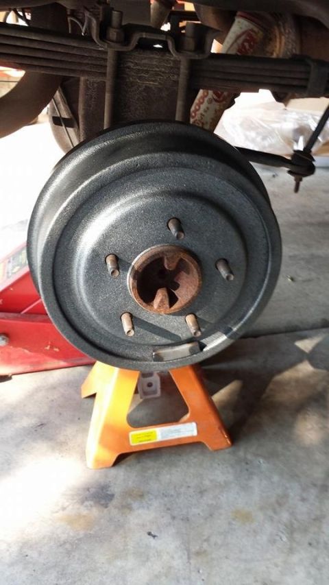 1996 Ford Bronco - Rear drum brake assembly supported by jack stands, showing suspension components above.