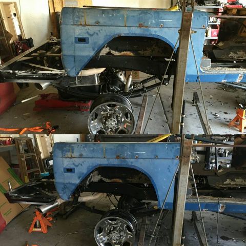 1979 Ford Bronco - A blue 1979 Ford Bronco is suspended on a lift in a workshop, undergoing repairs or restoration.