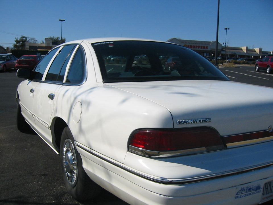 White 1994 Ford Crown Victoria parked in a lot, rear quarter view. "CROWN VICTORIA" badge visible on trunk lid