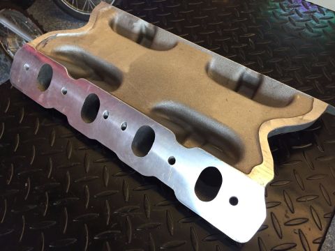 1972 Ford Ranchero - Close-up of an aluminum intake manifold, likely for a V8 engine, on a textured metal surface.