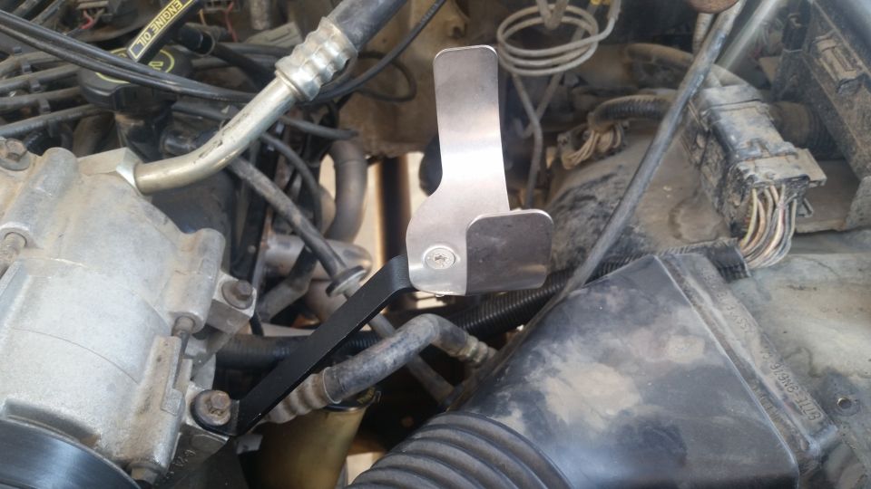 Brushed metal bracket installed in a 1992 Ford Bronco engine bay.