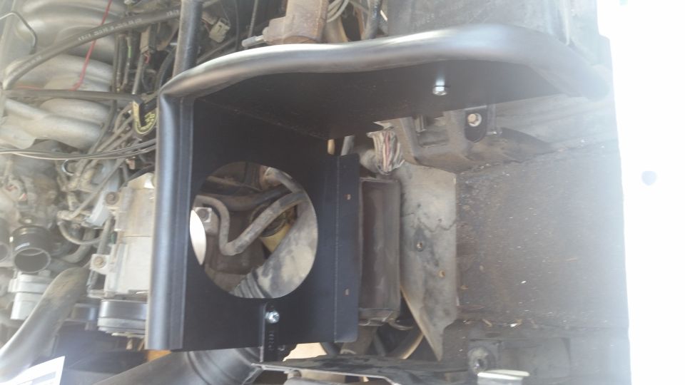 Black metal bracket with circular opening in engine bay of 1992 Ford Bronco.