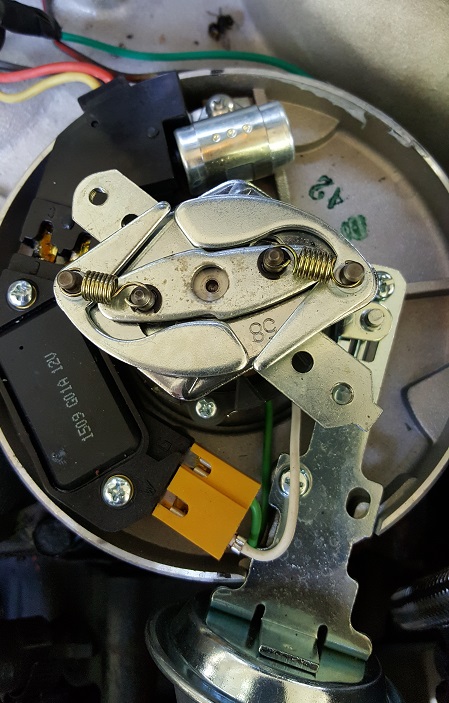 1978 Ford Bronco - A close-up view of the internal components of a vehicle's distributor, including the breaker points, springs, and ignition module. The modu…
