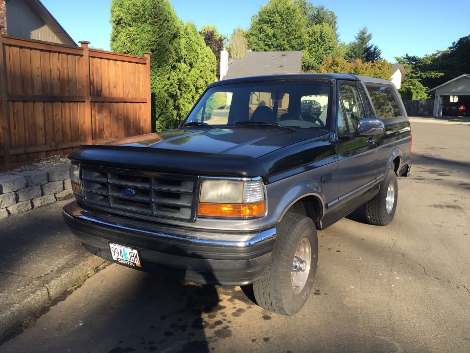 1995 Ford Bronco parked on a street, front 3/4 view.