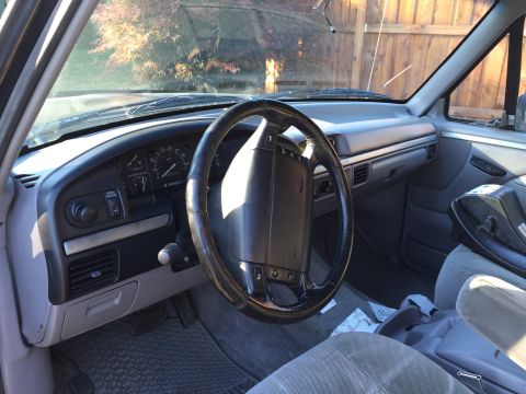 1995 Ford Bronco - The interior of a 1992 Ford Bronco is visible, with a focus on the dashboard and steering wheel.