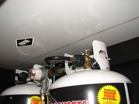 1973 Ford Ranchero - Close-up view of two propane tanks, showing regulators and hoses, with a 'Propane' sticker on the overhead surface.