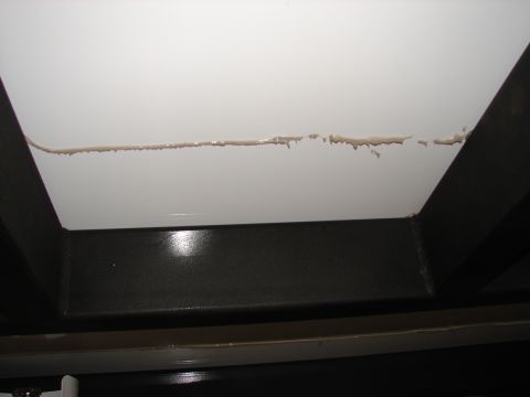 1973 Ford Ranchero - Sealant applied to a seam on a white trailer surface, with dark metal framing visible below.