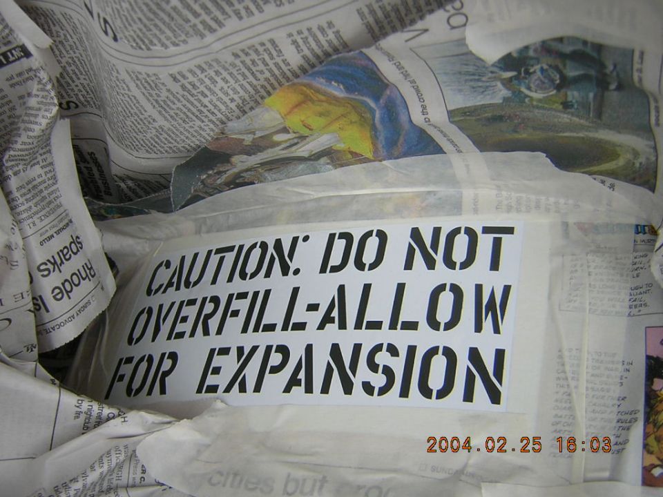 Caution: Do Not Overfill-Allow For Expansion label on crumpled packing paper