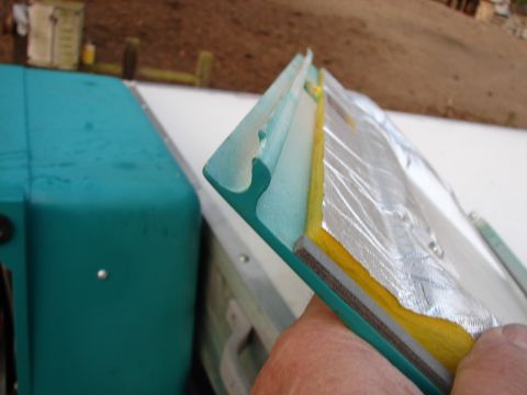 1973 Ford Ranchero - A hand holds a section of a teal trailer door seal, revealing its layered construction and insulation.