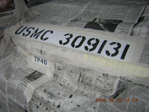 1984 Chevrolet Blazer - A stencil with USMC 309131 is being applied to a surface covered with newspaper.