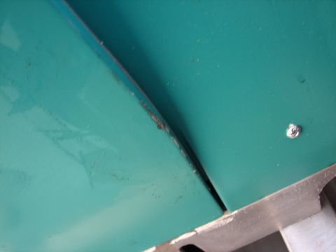1973 Ford Ranchero - Close-up of a teal painted metal panel seam showing rust and a screw.