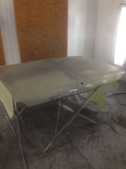 1964 Ford Fairlane - A car hood is prepped for painting inside a booth.