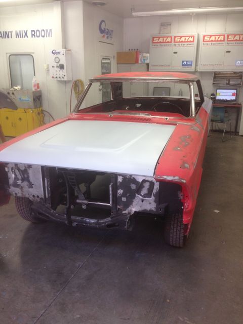 1964 Ford Fairlane - A classic car is being prepped for paint in a booth with equipment and tools visible.