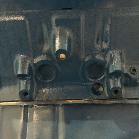 1978 Ford Bronco - Close-up of a blue engine block showing various ports and mounting points.