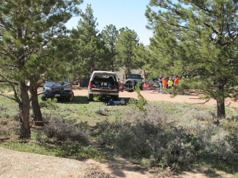 1996 Ford Bronco - A group of people and their vehicles are gathered in a natural setting, possibly for an outdoor activity.