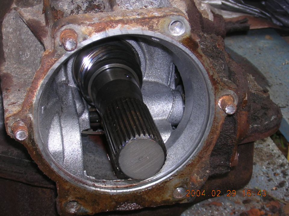 Close-up of a rusty differential housing with a splined shaft visible inside