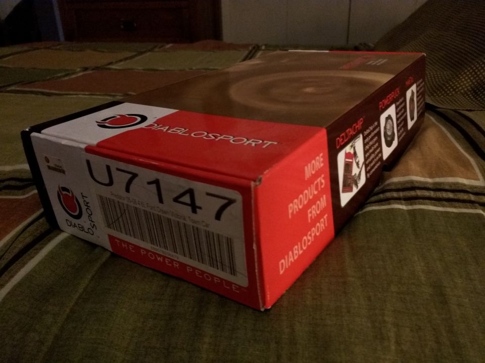 DiabloSport U7147 power programmer box on a bed.