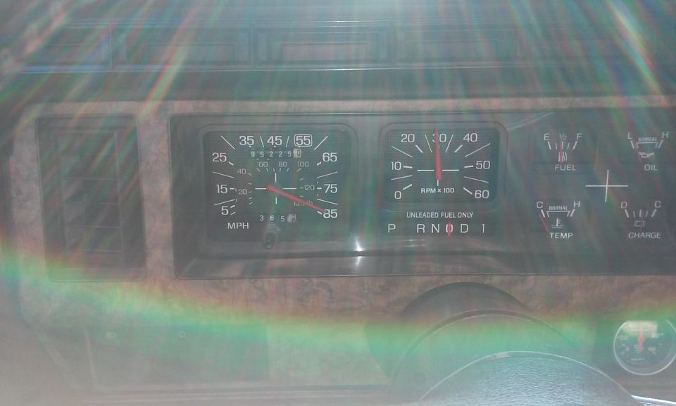1986 Ford Bronco dashboard with speedometer, tachometer, fuel, oil, temp, and charge gauges. Vehicle in park.
