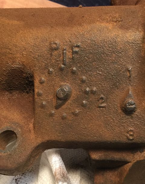 1978 Ford Bronco - A close-up, rusted metal part with stamped markings that read "PIF" and "2". Another marking appears to be a "1" and a "3" further to the r…