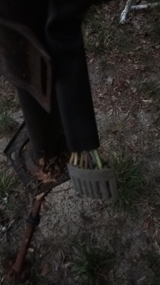Exposed wires from a black cable secured by a gray clamp, attached to a dark cylindrical object.