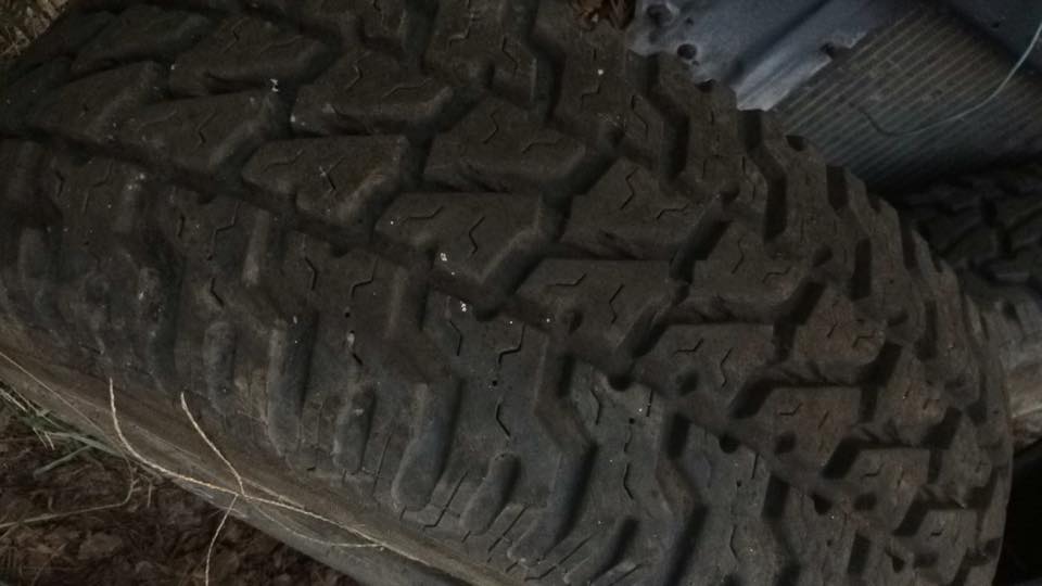 Close-up of a dark off-road tire with aggressive tread.
