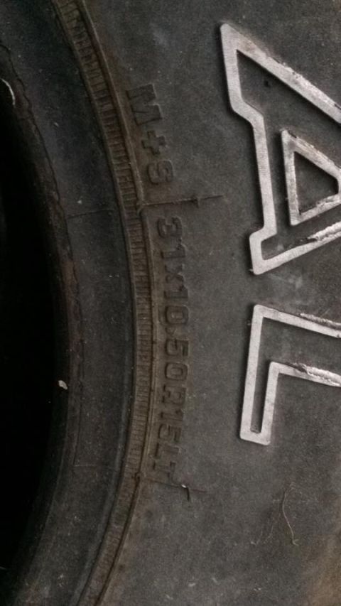 1996 Ford Bronco - A close-up of a tire shows the sidewall markings "M+S" and "31X10.50R15LT". The letters "AL" are visible on the tire tread in the backgroun…