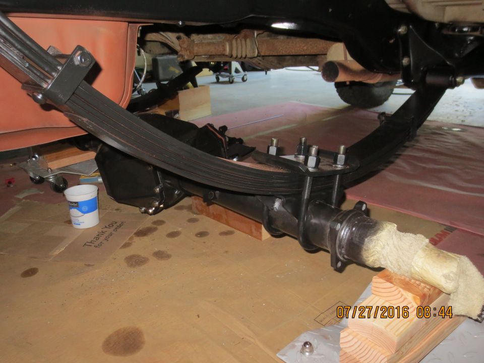 Underside of a vehicle showing leaf spring suspension and differential housing.