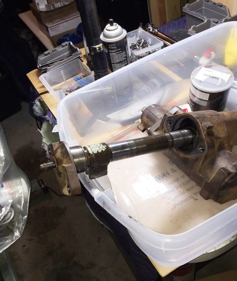 1978 Ford Bronco - A rusty steering gear assembly with a shaft extending from it is placed inside a clear plastic bin. Various automotive parts and tools are…