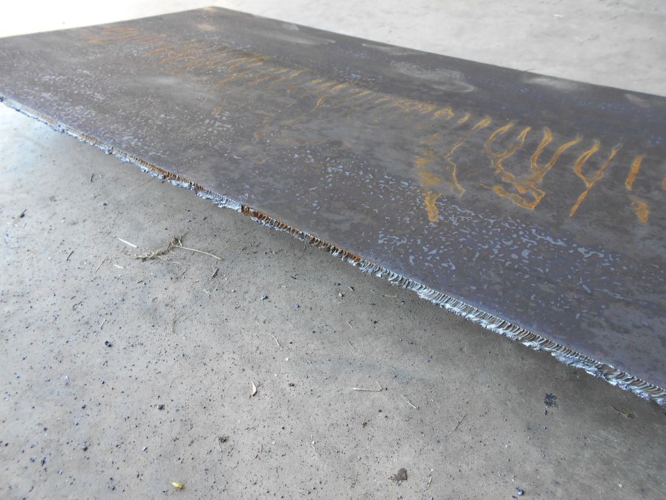 Large metal plate with rough cut edge on concrete