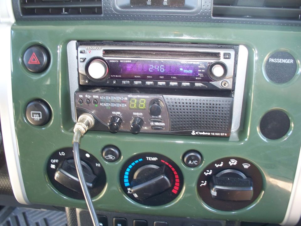 Center console of a green Toyota FJ Cruiser with Kenwood stereo and Cobra CB radio.