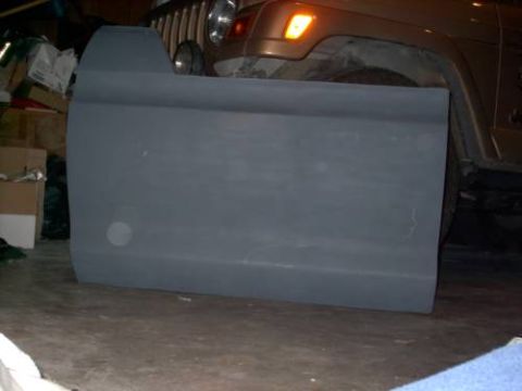 1978 Ford Bronco - A gray vehicle door is the main focus, with a Jeep partially visible behind it.