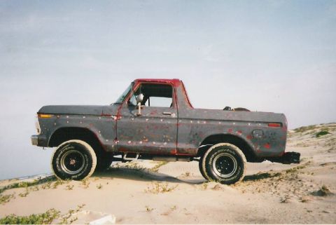 1978 Ford Bronco - A 1978 Ford Bronco sits on a sandy dune under a clear sky.