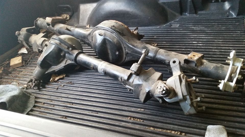 Two Ford rear axle assemblies in a pickup truck bed.
