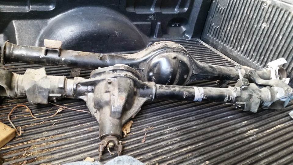 Two Ford rear axle assemblies in a pickup truck bed.