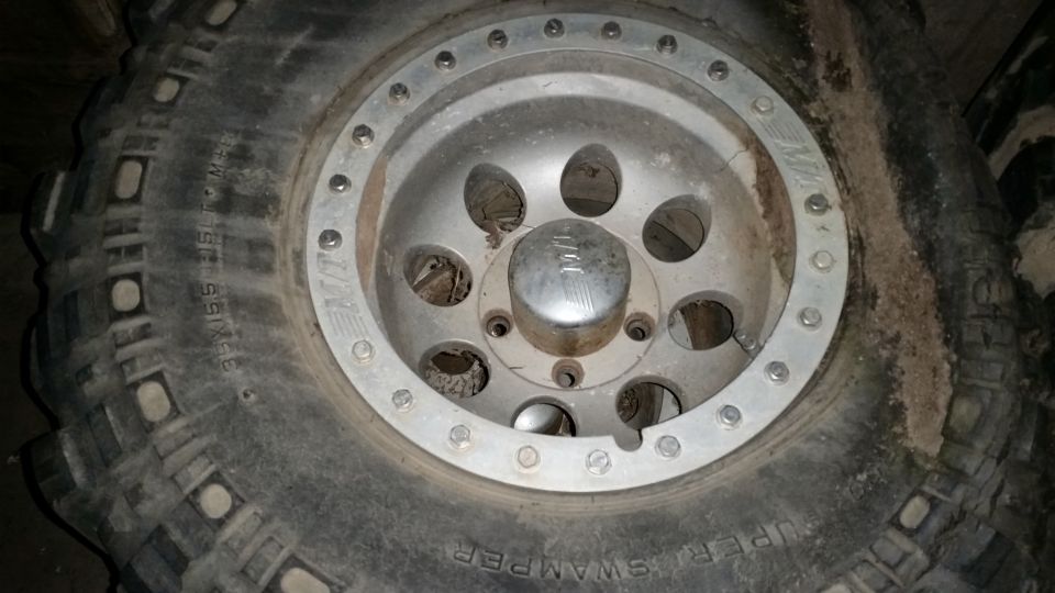 Aluminum beadlock wheel on a Super Swamper mud tire, close-up