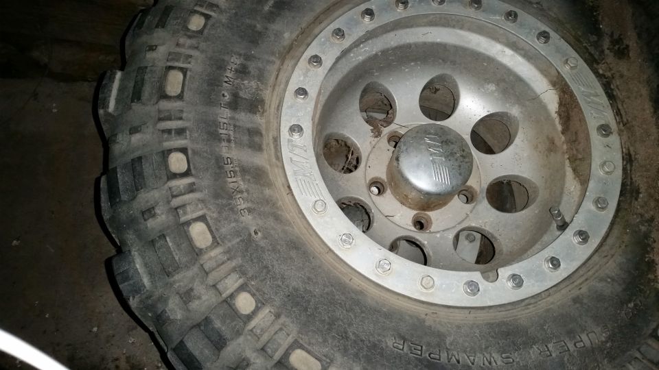 Close-up of a 35x15.5 R15LT M+S Super Swamper tire on a silver alloy wheel.
