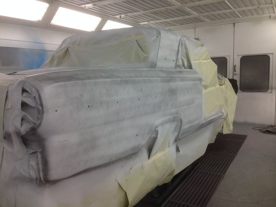 1964 Ford Fairlane covered in masking for paint booth.
