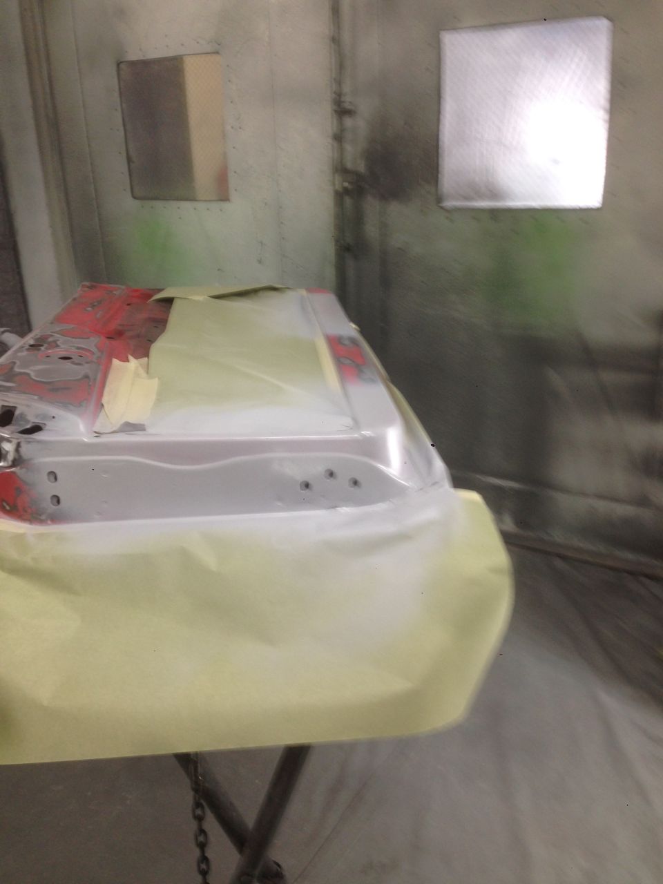 Car door covered in masking paper in a paint booth