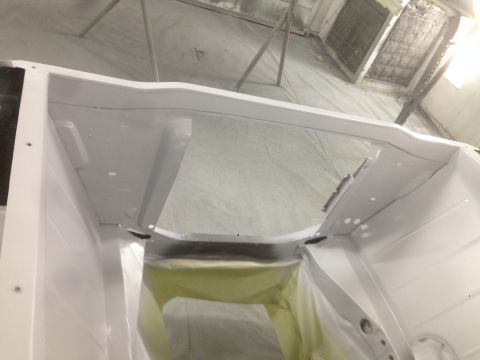 1964 Ford Fairlane - The interior of a car is masked off and prepared for painting in a workshop.