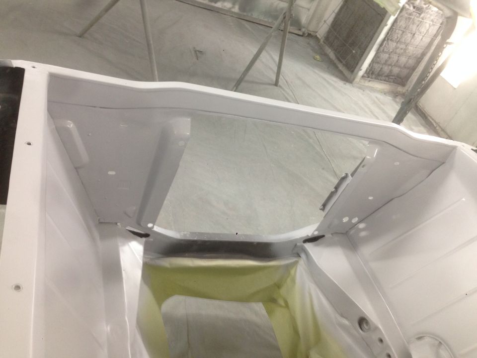 White car interior, masked for painting, showing firewall and dashboard area