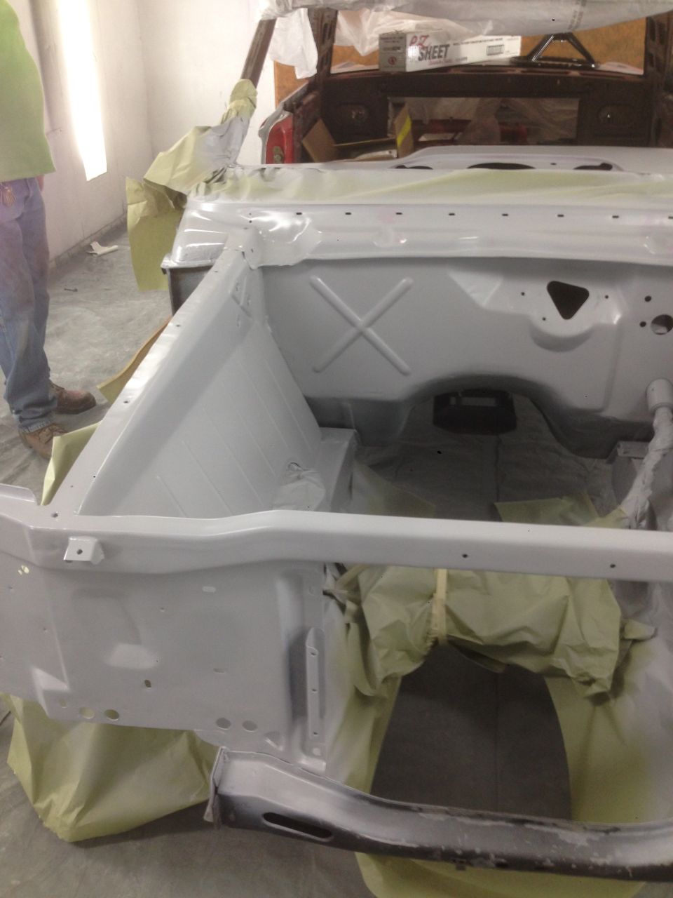 1964 Ford Fairlane body, primed and masked for paint. Engine bay area is visible