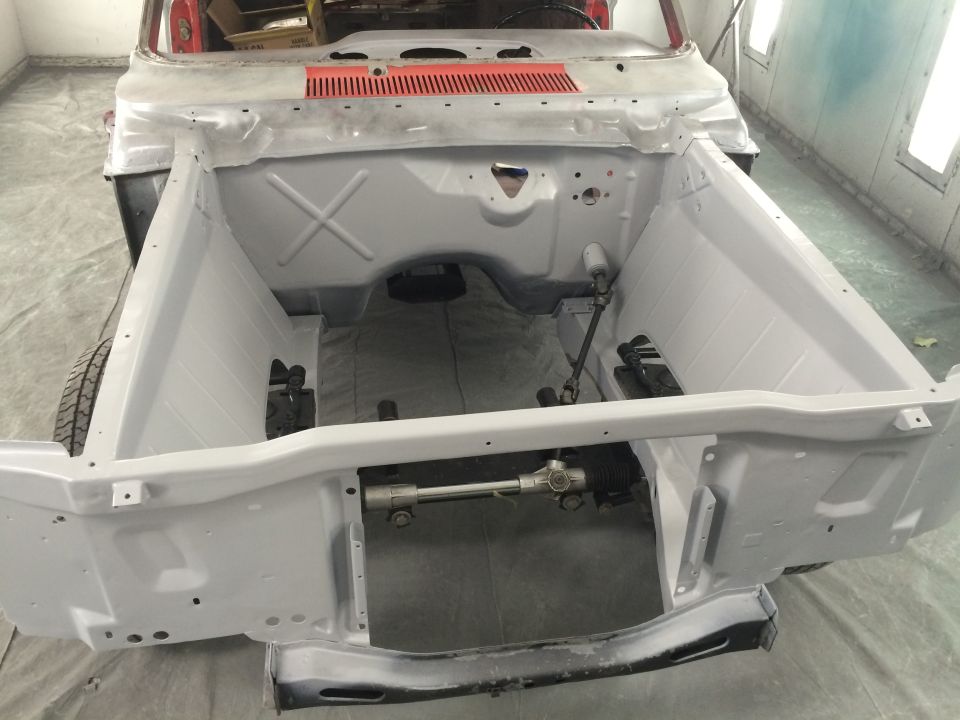 1964 Ford Fairlane chassis with primer applied, showing steering rack and firewall