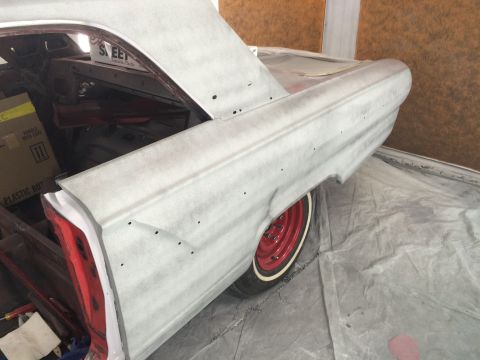 1964 Ford Fairlane - The rear quarter panel of a 1964 Ford Fairlane is shown, prepped for paint with red wheels and whitewall tires visible.
