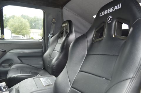 1992 Ford Bronco - The interior features aftermarket Corbeau racing seats and a center console with a metallic plate.