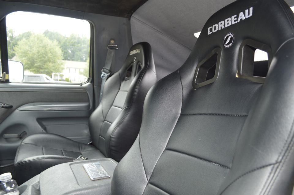Interior view of truck with two black Corbeau racing seats and a center console