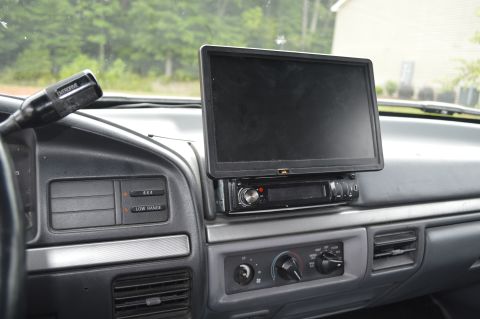 1992 Ford Bronco - Interior view of a vehicle's dashboard an aftermarket screen and radio unit.